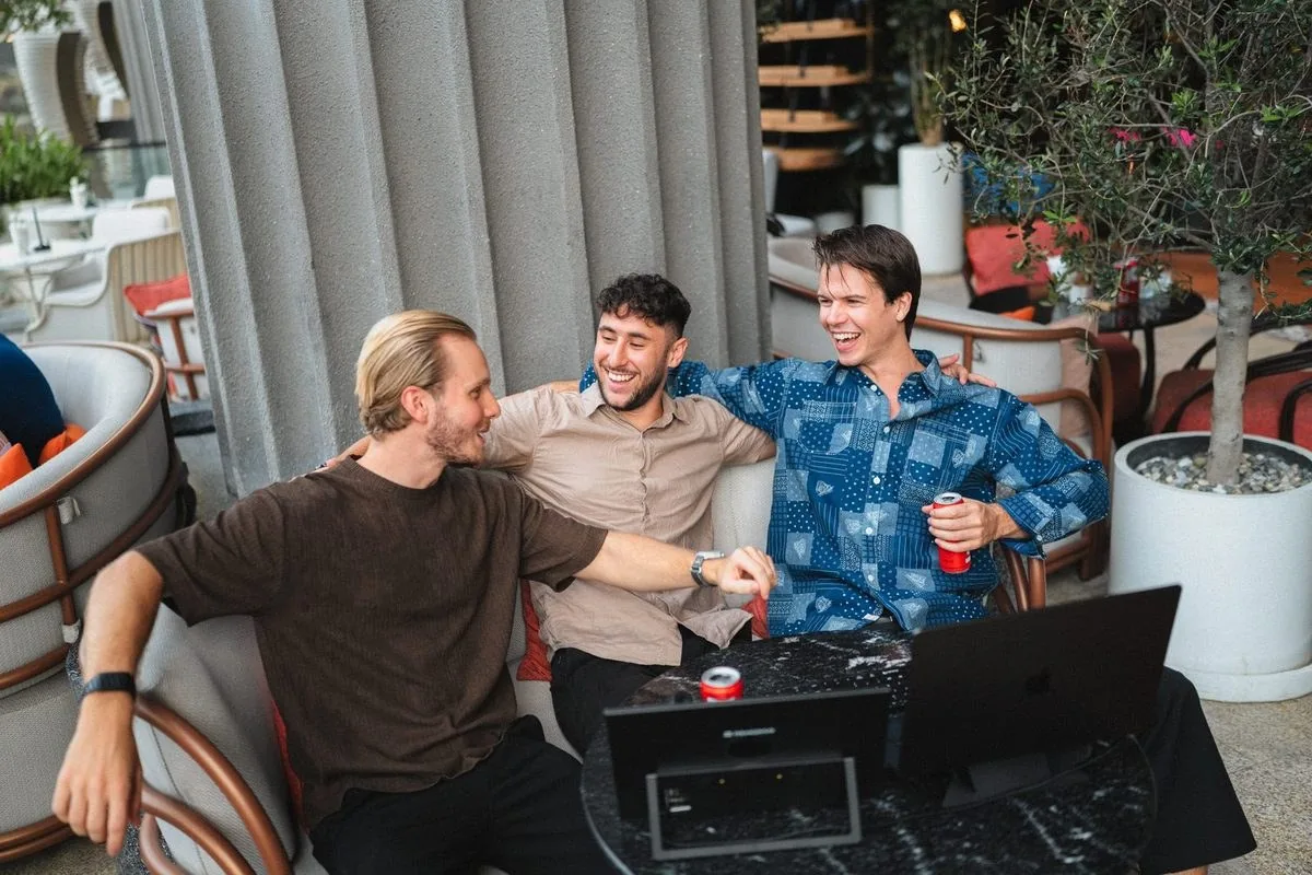 People brainstorming and laughing around a portable monitor